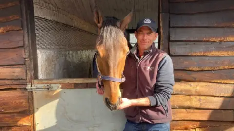 Man stood looking at horses