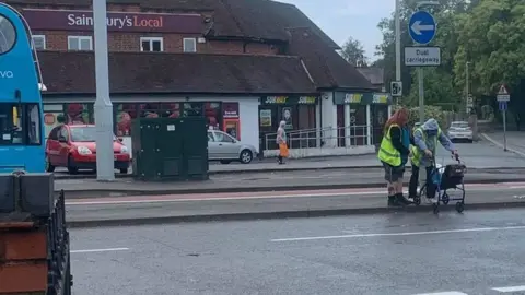 Gemma Cooke Jackie King helping a customer cross the road