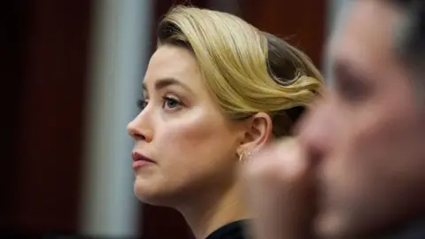 Getty Images Actress Amber Heard listens in the courtroom at the Fairfax County Circuit Courthouse in Fairfax, Virginia, April 25, 2022.