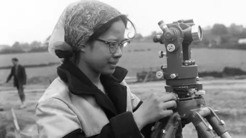 Historic England/John Laing Collection A woman makes measurements making the M6