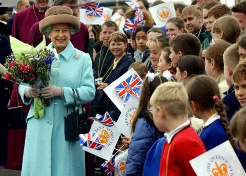 PA Media The Queen talks with a group of children after she had opened the Millennium Bridge between Newcastle and Gateshead on her visit to the North East on 7 May, 2002.