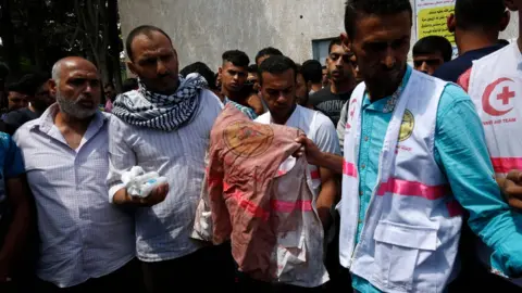 AFP Father (second left) of Razan al-Najar holds her jacket covered with blood during her funeral in Khan Younis on June 2, 2018