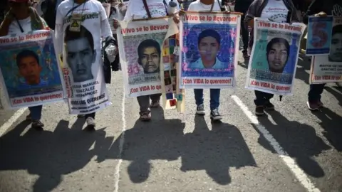 AFP In this file photo taken on September 26, 2019 people protest in Mexico City to mark five years of the disappearance of the 43 students of the teaching training school in Ayotzinapa