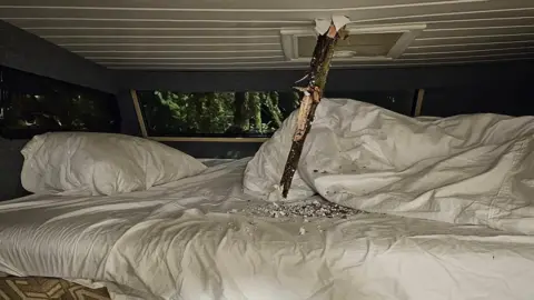 Aaron Waterer The roof of a motorhome pierced by the branches of a tree torn off