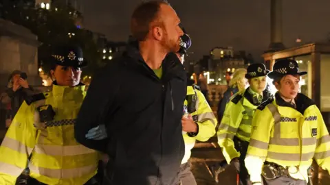 PA Media Police remove an Extinction Rebellion protester from Trafalgar Square in central London