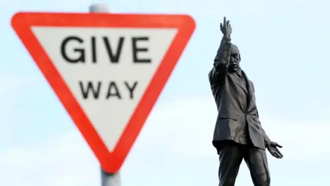 AFP A 'Give way' sign next to the statue of former unionist leader Lord Carson at Stormont