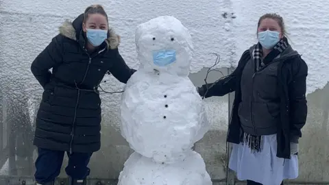 Gemma Lister NHS staff members Danielle Howlett and Nikki Brooks with a snowman