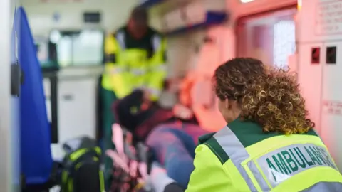 Getty Images Paramedics treat a patient in an ambulance