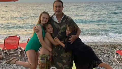 Family picture The father and three children on a beach