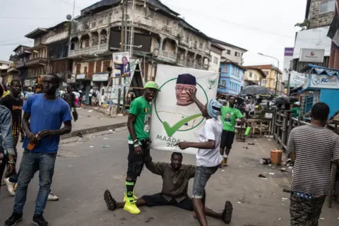 John Wessels/AFP Supporters of the president of Sierra Leone and leader of Sierra Leone People's party (SLPP), Julius Maada Bio, celebrate in the streets following his re-election in Freetown - Tuesday 27 June 2023