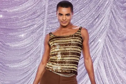 Ray Burmiston/BBC Layton Williams in a sparkly top and brown trousers