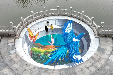 AFP People look at a street painting in Handan, in China's northern Hebei province on 20 September 2022
