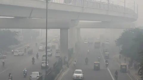 Getty Images A Delhi Metro train (top) and vehicles drive past amid heavy smog in New Delhi on November 5, 2018