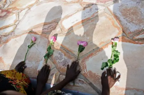 AFP Rwandese refugees in Uganda place flowers as they pray at Kasensero Genocide Memorial site in Rakai District on April 21, 2018 as they mark the 24th anniversary of the 1994 genocide against the Tutsi people in Rwanda.