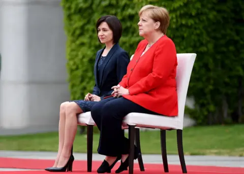 AFP German Chancellor Angela Merkel (R) and Moldova's Prime Minister Maia Sandu sit as they listen to the national anthems during a welcoming ceremony with military honours at the Chancellery in Berlin on July 16, 2019