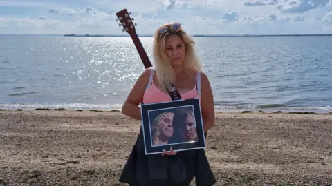 Emma Cain Emma Cain standing on Southend seafront with a picture of her son, Jon Cain