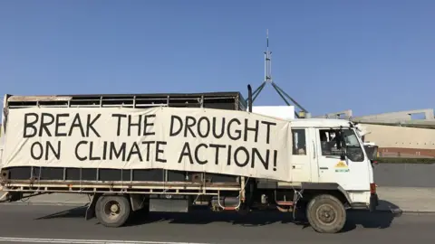 Farmers for Climate Action A lorry drives past parliament with a big sign on the side which reads: 'Break the drought on climate action!'