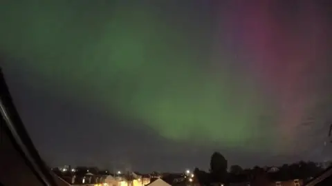 Northern Lights shining green and pink in the nightsky