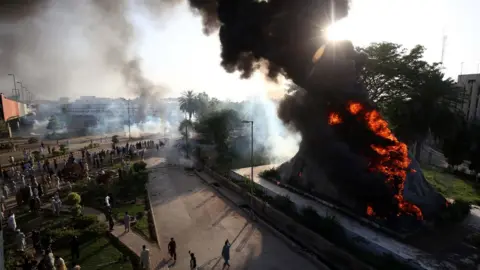 EPA Flames rise from the Radio Pakistan premises after it was set on fire during clashes between police and supporters of Pakistan's former Prime Minister Imran Khan protesting against his arrest, in Peshawar, Pakistan, 09 May 2023.