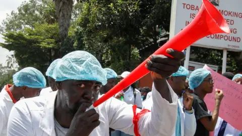MONICAH MWANGI/REUTERS A medical practitioner participates in a demonstration against the government's failure to hire trainee doctors, outside the Ministry of Health in Nairobi, Kenya, March 4 2024