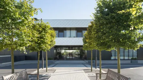 Artists impression of the Sulis hospital with green trees outdoors