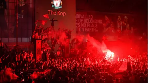 Getty Images Crowd of Liverpool fans in front of The Kop celebrating Premier League title win