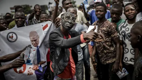 Getty Images Supporters of opposition leader Martin Fayulu sing and dance as they march and chant slogans in the streets of the Ndjili district of Kinshasa on 19 December 2018