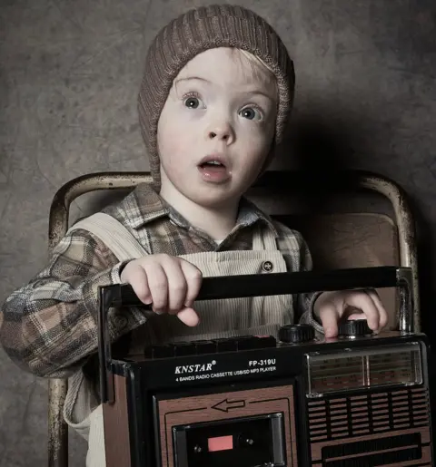 Debbie Todd A young boy holds an old radio