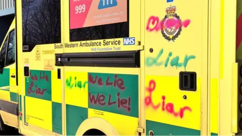 BBC Graffiti reading 'liar' spray-painted over a South Western Ambulance Service NHS Foundation Trust ambulance