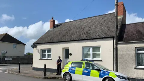 Police officer outside house in Pembroke Dock