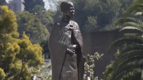 EPA Officials gather around a statue of a spirit medium known as Mbuya Nehanda (C) soon after it"s unveiling by Zimbabwean President Emmerson Mnangagwa during the Africa Day celebrations in Harare, Zimbabwe, 25 May 2021. Zimbabwe has joined many other African countries in commemorating Africa Day, that marks the creation of the Organisation of African Unity on 25 May 1963