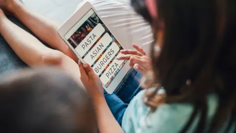 Getty Images A child ordering food on a meal delivery app