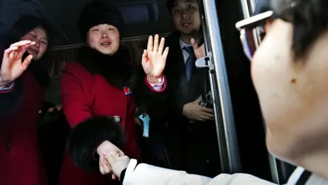 EPA North Korean members of the joint inter-Korean women's ice hockey team bid a tearful farewell to their South Korean companions as they leave Gangneung Olympic Village