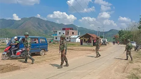 Getty Images Indian army soldiers patrol along the violence hit area of Dolaithabi village in Manipur state on May 29, 2023.