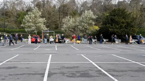 PA Media Shopper queue outside a Tesco in West London