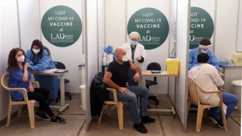 Reuters People receive Covid vaccination in Beirut (Feb 2021)