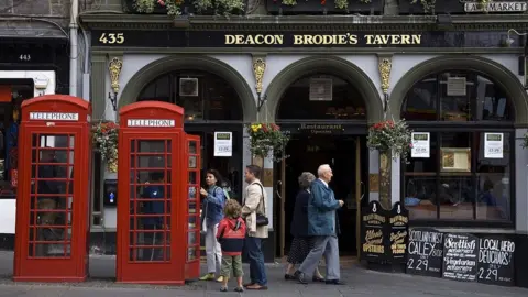 Getty Images Two red phone boxes on Edinburgh's Royal Mile.