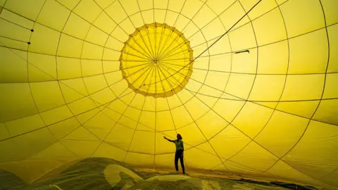 Ben Birchall/PA Wire Inside a yellow hot air balloon canopy