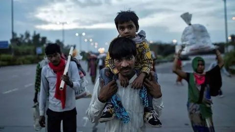 Reuters Dayaram Kushwaha carries his 5-year-old son, Shivam, as he and members of his extended family make their way back to his home village from New Delhi.