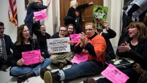 Getty Images Protesters sat in the halls of Congress to oppose the tax cuts earlier this month