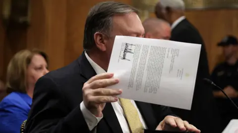 Getty Images Pompeo holds up letter