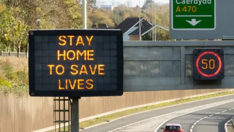 Getty Images Stay home to save lives sign on motorway