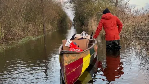 Harry Linder Man with canoe on a flooded road in Surlingham