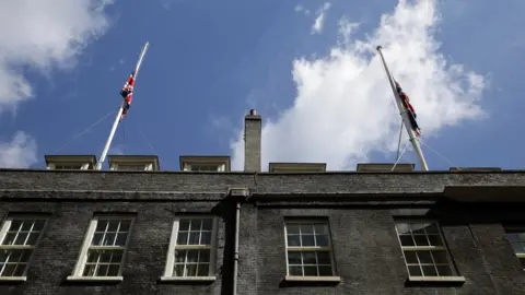 Reuters Union flags at half-mast on the roof of Downing Street