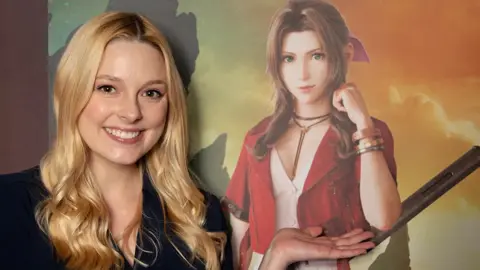 Briana White A young woman with long, blonde hair smiles as she stands with her palm held out and upturned in front of a large poster. Her hand is drawing attention to the computer-generated image of a character with brown hair, tied back half-up, half-down with a pink ribbon, wearing a leather shoelace-style choker necklace and red jacket over a pink dress.