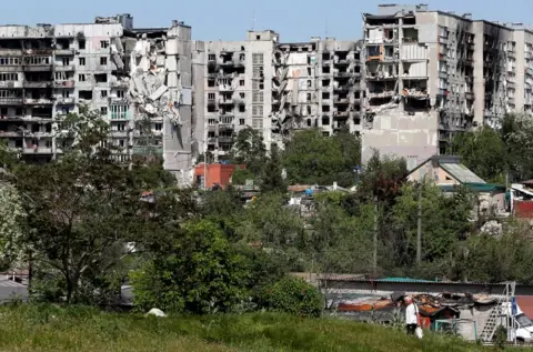 Reuters Residential buildings have been heavily damaged by Russian shelling in the southern port city of Mariupol, Ukraine, 30 May 2022