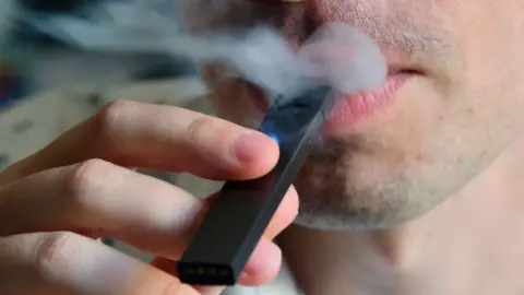 Getty Images Man using a vape pen.