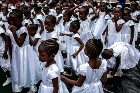 AFP Young Catholic faithful are seen during the inauguration of the new Archbishop of Kinshasa, Fridolin Ambongo in Kinshasa, DR Congo - 25 November 2018