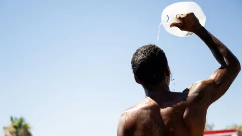 A man pours water on himself in Phoenix