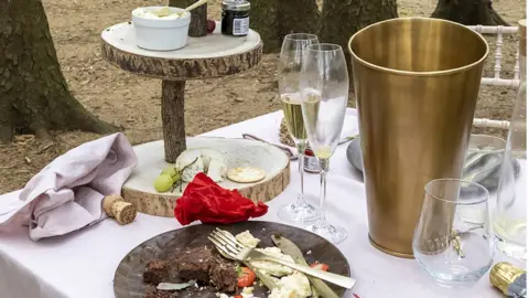 Ashley Cooper GWI Remains of half eaten food and champagne cork and glasses